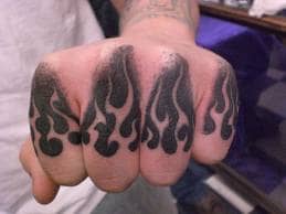 Flame tattoos on the knuckles.