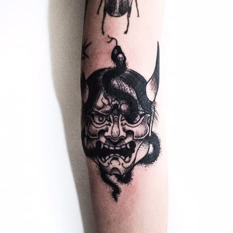 A hannya mask tattoo that incorporates a snake.