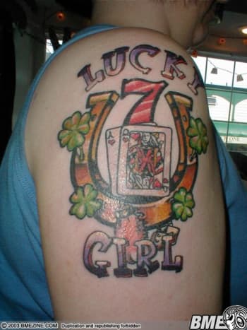 Lucky tattoos often incorporate multiple symbols. This one has a horseshoe, clovers, a rabbit's foot, the number seven, and dice, along with playing cards.