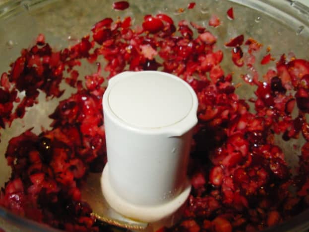 The cranberries are coarsely chopped in a food processor.