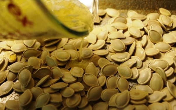 Drizzle the pumpkin seeds with 2 tbsp melted butter.
