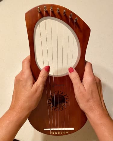 Held in front using thumbs to pluck strings.