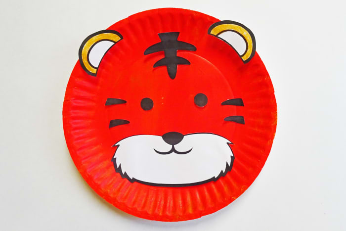 The finished paper plate tiger. For this craft, a white paper plate was painted orange with acrylic paint. You could also purchase orange paper plates for this craft.