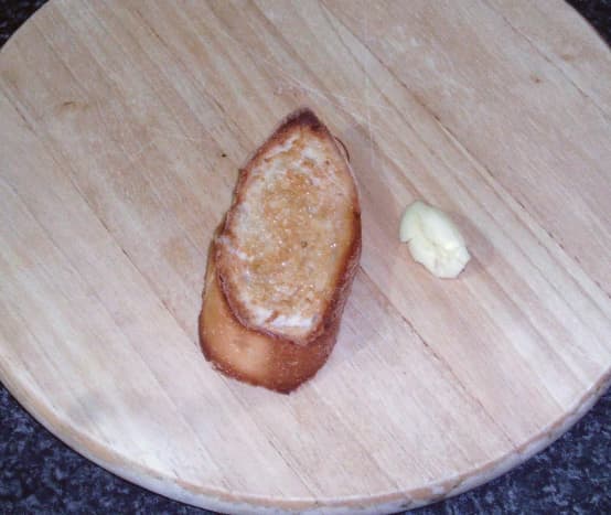 Hot toast is rubbed with crushed garlic clove.