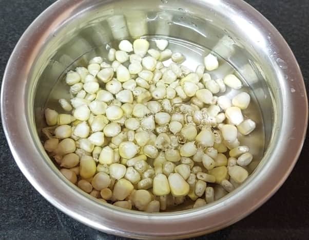 Add 1/2 cup of sweet corn kernels to a pot. Add 1/2 cup of water and cook.