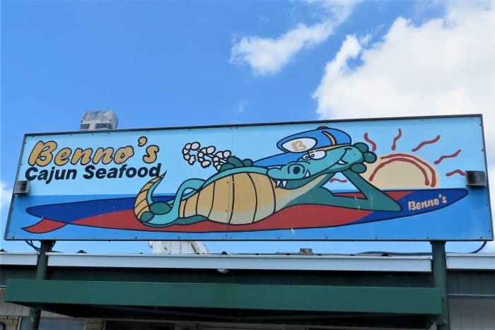 A whimsical exterior sign with an alligator at Benno's Cajun Seafood Restaurant