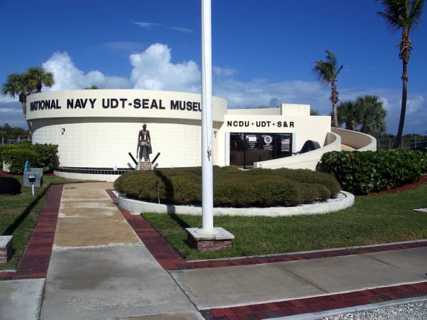 An old-time a frogman stands outside the entrance to the Navy UDT-SEAL Museum in Fort Pierce.