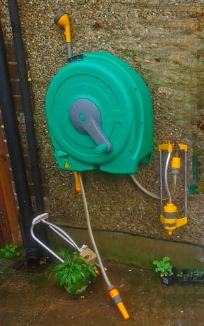 This is my Hozelock reel hanging on the wall, with various attachments - a spray head (above) and a garden sprinkler (below)