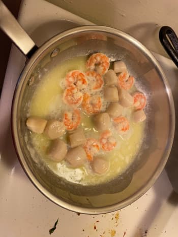 The shrimp turn pink and curl inward and the scallops go from translucent to white and become more firm. Remember, do not over cook the seafood or it will become rubbery.