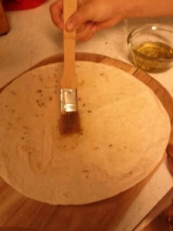 Brush one side of a large tortilla with melted butter or olive oil.