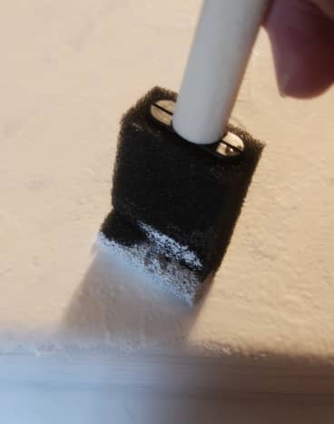 Using a combination of white and silver acrylic paint, paint your bucket using your paint brush. Let dry completely. For the second layer, use a foam brush to tap the paint onto your bucket. Let dry completely.