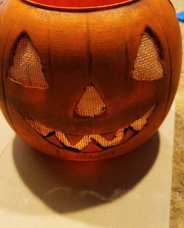 Cut burlap to size and hot glue to the inside of your pumpkin. This will cover your face pieces.