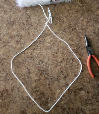 Reshape your wire hanger into a loose diamond shape. Twist the ends back around on each other to hold. 