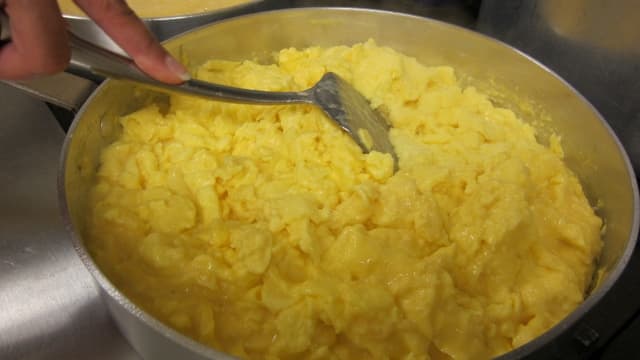 Fluffy scrambled eggs are prepared from scratch with cheese.