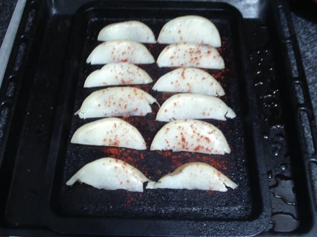Seasoned potato wedges ready for baking