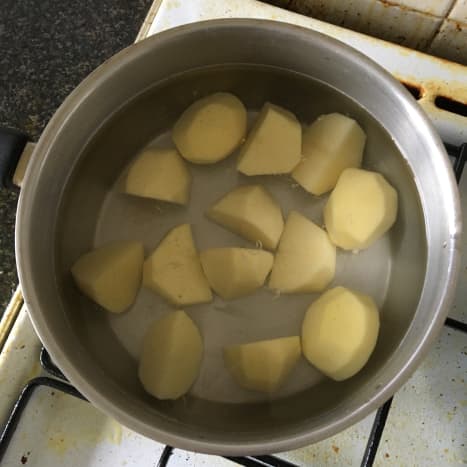 Chopped potatoes are added to cold salted water and put on to reach a boil
