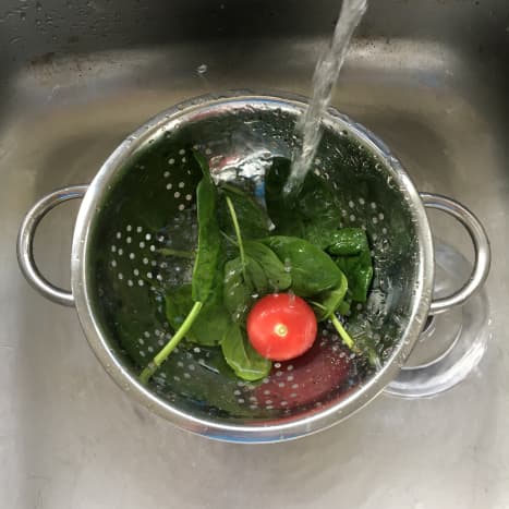 Spinach leaves and tomato are thoroughly rinsed in cold water
