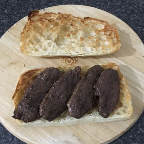 Rested goose strips are laid on panini base