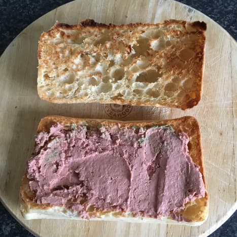 Garlic infused Brussels pate is spread on bottom half of toasted panini