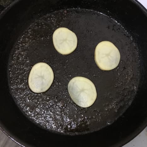 Potato slices are added to hot pan