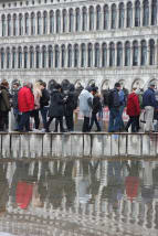 Venezia, Piazza San Marco allagata. La gente è costretta a camminare sulle passerelle dei grattacieli.'s Square, flooded with water. People have to walk on the high-rise walkways.