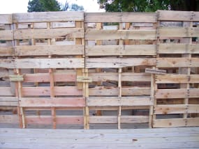 In unserem Labyrinth von 2014 wurden Holzpaletten für die Wände verwendet. Sie wurden mit 2,5''-Nägeln zusammengefügt. Wir haben die Paletten direkt zusammengenagelt und mit kleinen Holzstücken verbunden. Diese wurden dann mit Pappe und schwarzem Plastik abgedeckt.