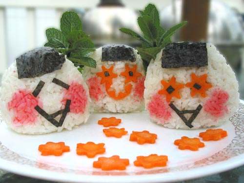 Slices of carrot, bits of nori (seaweed) and rice stained pink as decoration