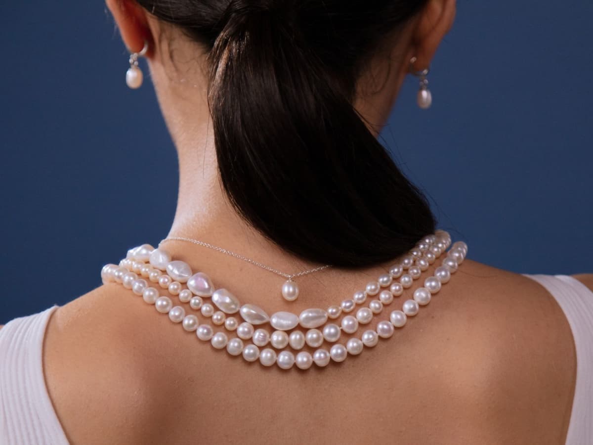 Pearl necklace? Do you think these are real pearls? They are definitely not  plastic but the majority seem to have a flat bottom, what could these have  been made out of and