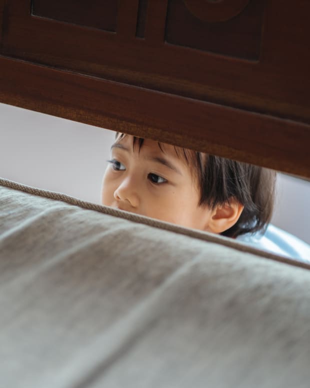 kid hiding under bed