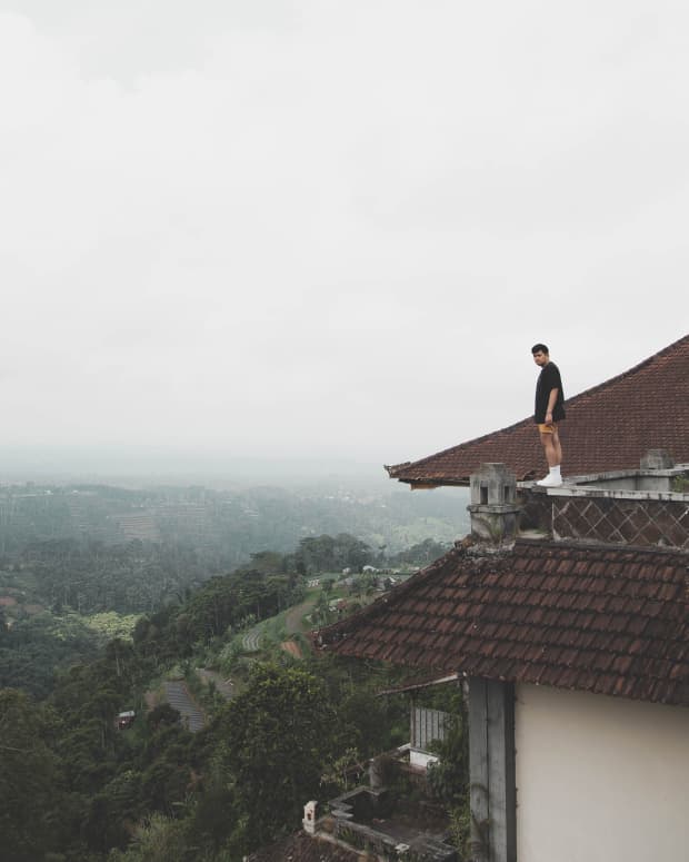 A man stands on the rooftop of an abandoned hotel in Bali