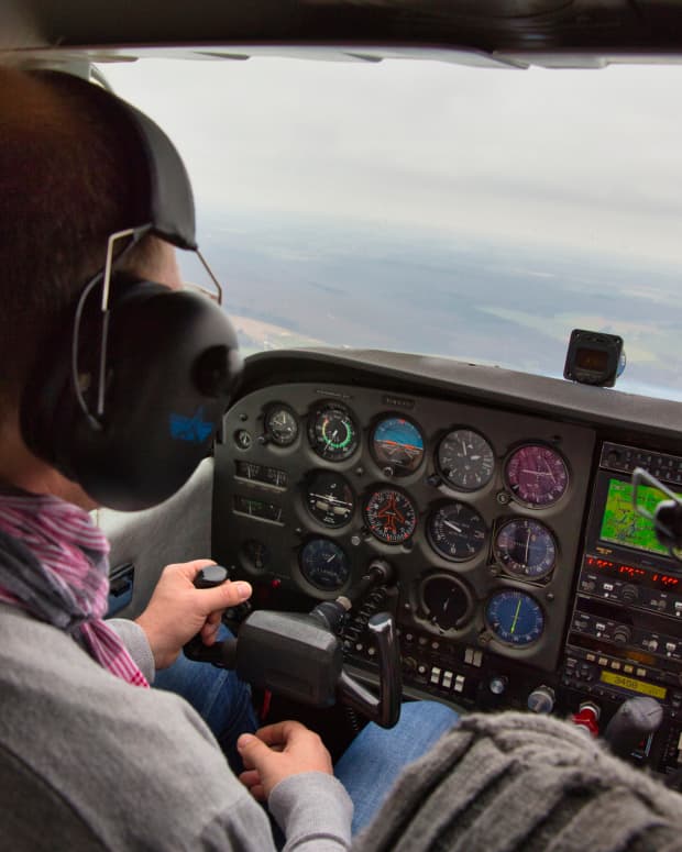 A pilot flying in the small cockpit of a Cesna