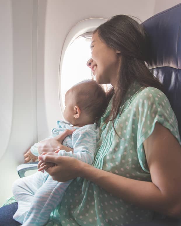 A mother and baby looking out their airplane window