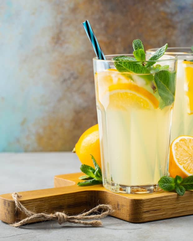 Two glasses of lemonade with mint on a cutting board