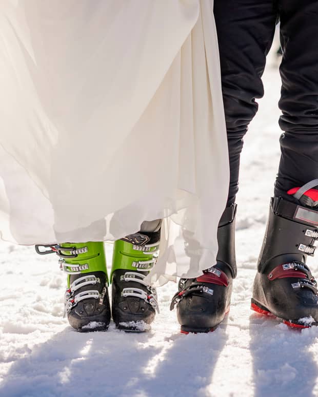 The feet of a bride and groom in ski gear