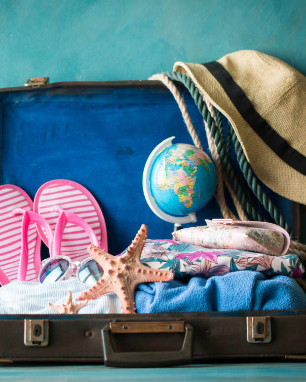 A packed vintage suitcase with a tropical vacation theme