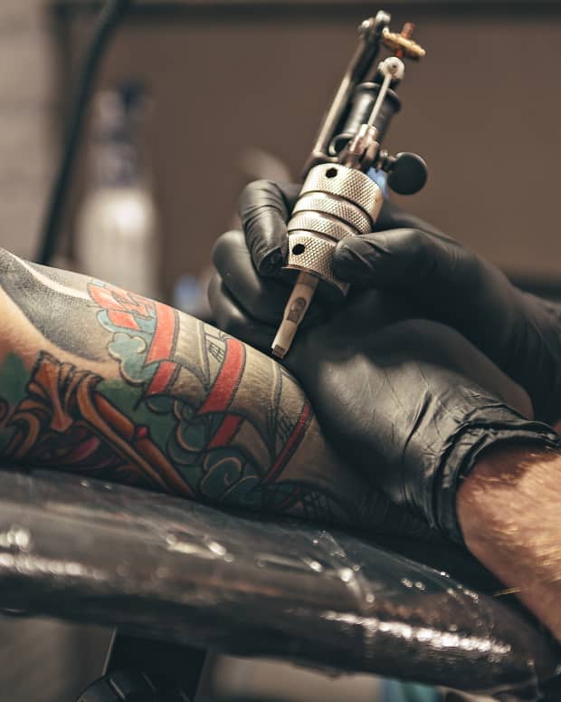 person getting arm tattooed