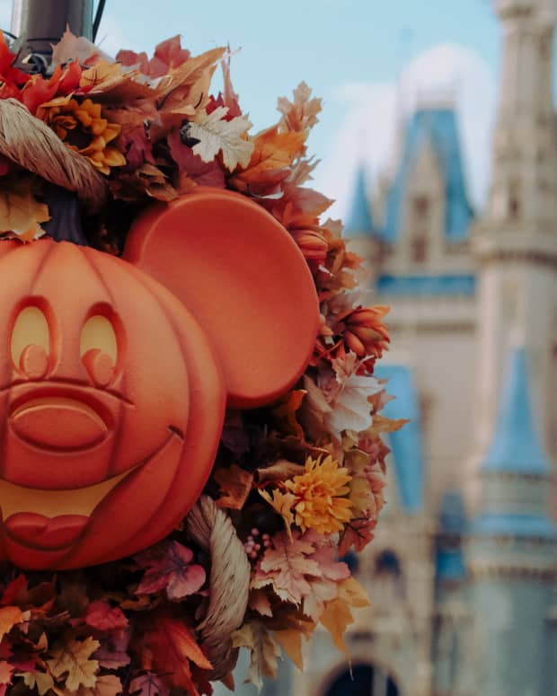 Foreground is a Mickey Mouse Halloween pumpkin decoration, background is Magic Kingdom's Cinderella castle
