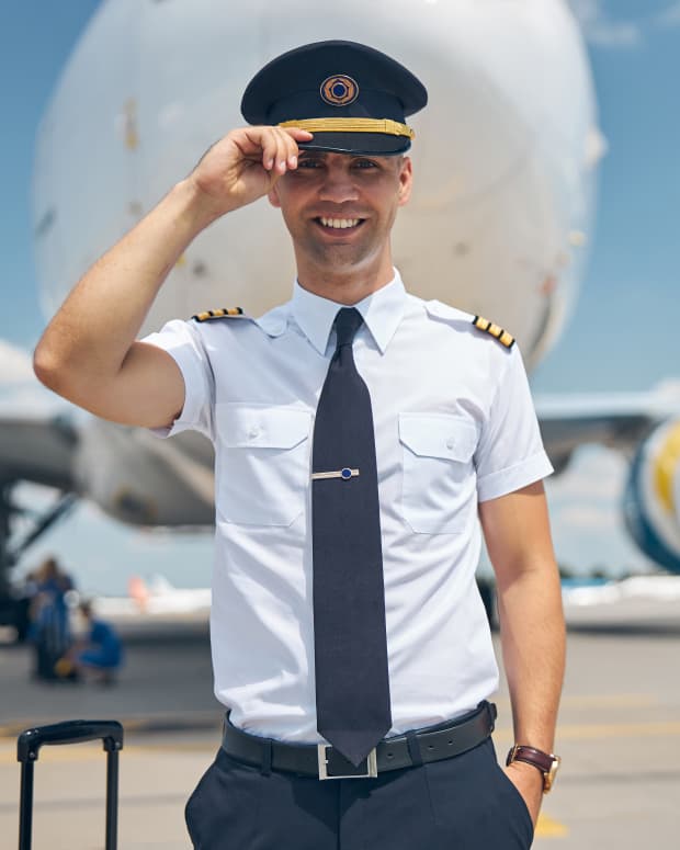 Smiling pilot next to his aircraft