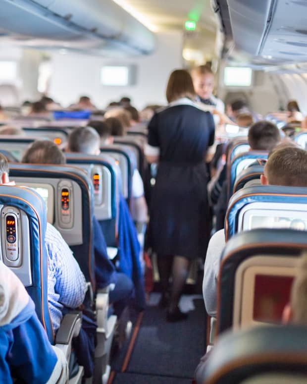 Passenger airplane cabin with flight attendants in the aisles