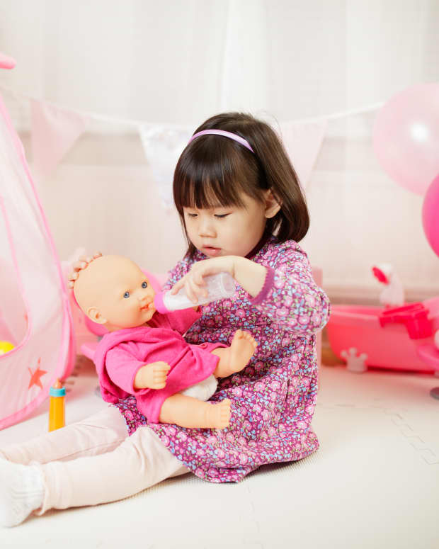 little girl playing with baby doll