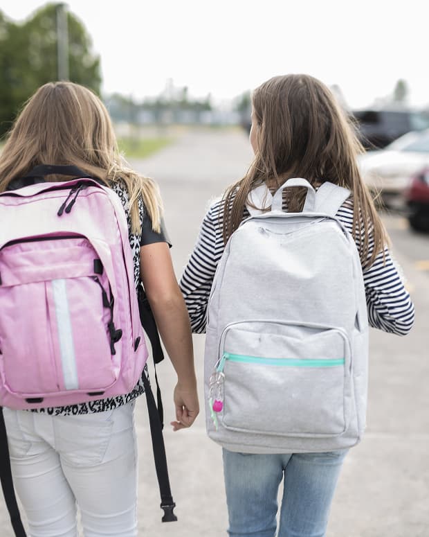 girls wearing backpacks at school