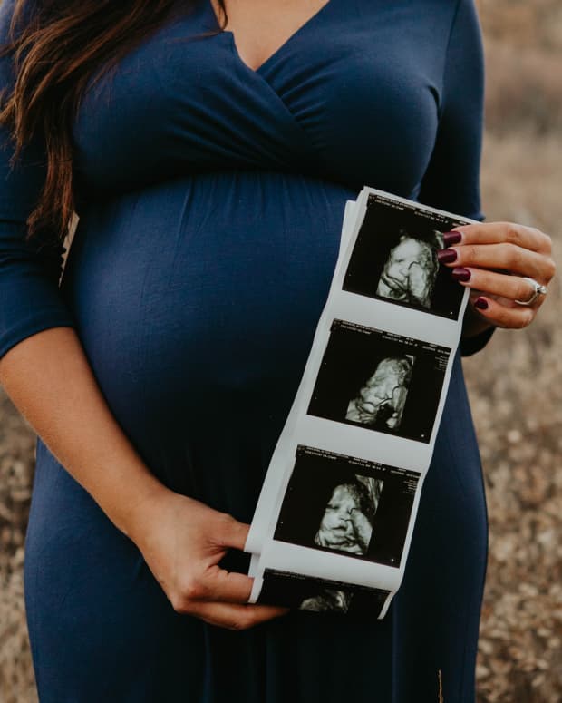 woman holding ultrasound photos