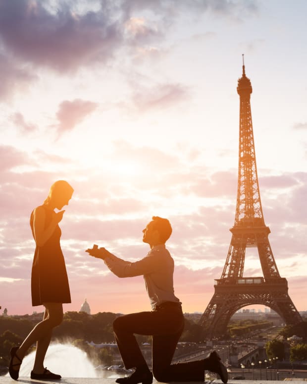 A man proposing to his female partner at sunset in front of the Eiffel Tower