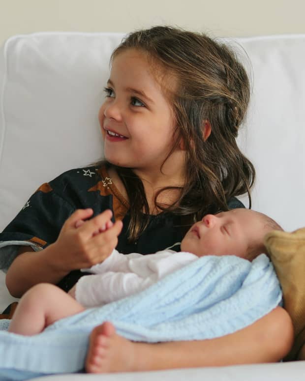 little girl holding baby brother