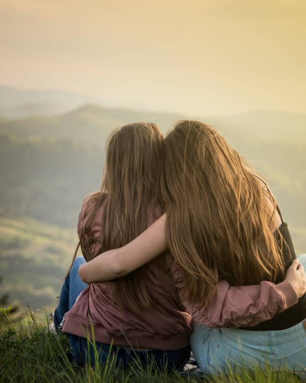 sisters hugging on a mountain