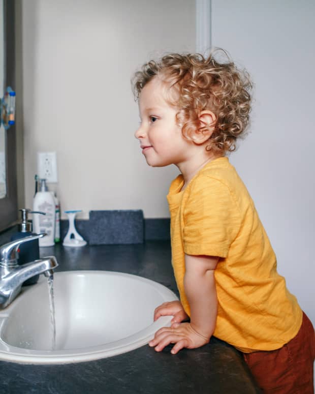 toddler standing at sink