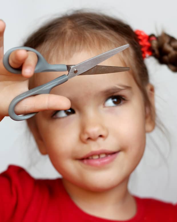 little girl holding scissors