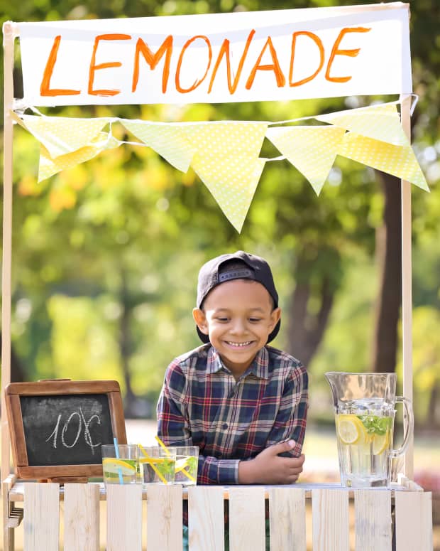child standing at a lemonade stand