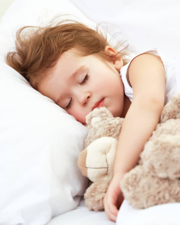 sleeping little girl holding teddy bear