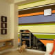 This modern accent wall with horizontal stripes in varying colors and widths is a great example of how painting only one wall can have a dramatic effect in a room. Photo is courtesy of http://www.flickr.com/photos/dansays